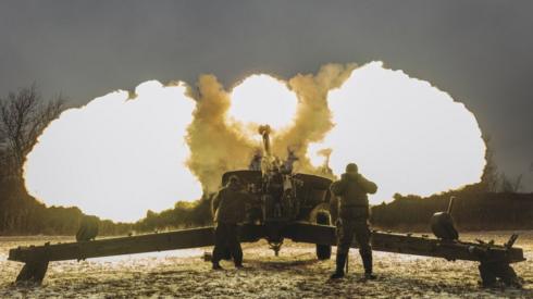 Ukrainian troops fire an artillery weapon