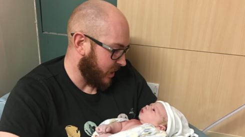 James Stokoe holds a baby