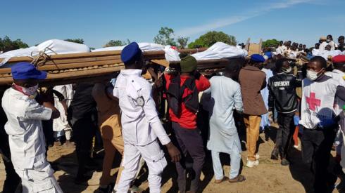 Men carry the bodies of people killed by militant attack, during a mass burial in Zabarmari, in the Jere local government area of Borno State, in northeast Nigeria, November 29, 2020.