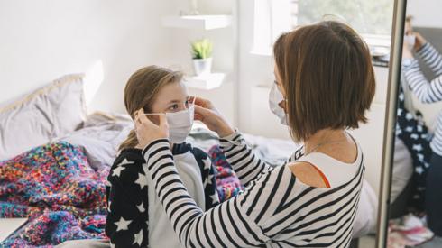 Woman putting mask on girl