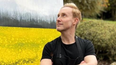 Ian in front of one of his paintings