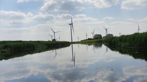 Clouds and a windfarm reflected in water