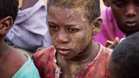 Children huddled on the floor at a makeshift school