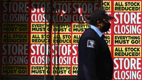 Man in mask walks past closed store in Brooklyn, NYC (May 2020)