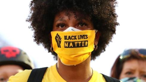 Protester in Portland with a face covering that says "Black Lives Matter" on it