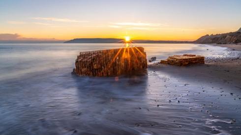 Brick wall on a beach at sunset