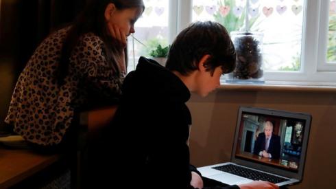 Children watch Boris Johnson speak on a laptop