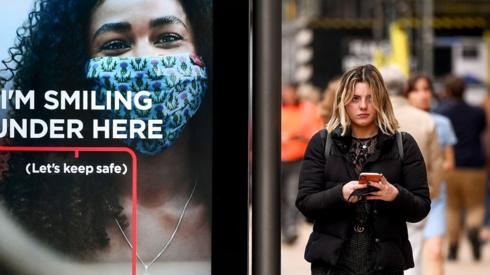 woman walking past sign