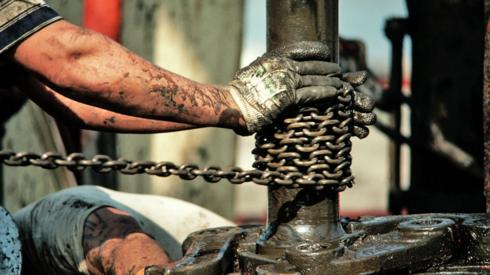 Stock image of two men working an offshore oil platform