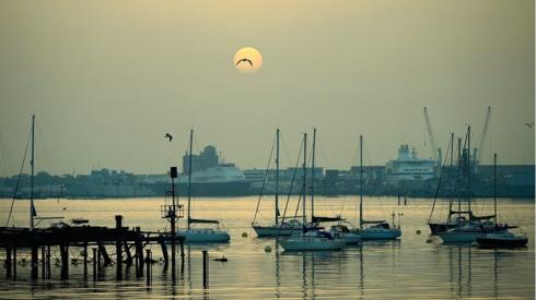 Boats moored up on water at sunrise