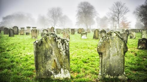 Two headstones in a grave yard on a misty day