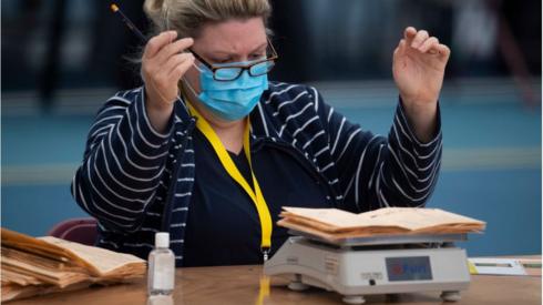 A woman reacts as votes are weighed during the Senedd election count at the Cardiff House of Sport