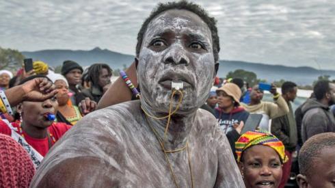 Man with a painted face blowing on a whistle