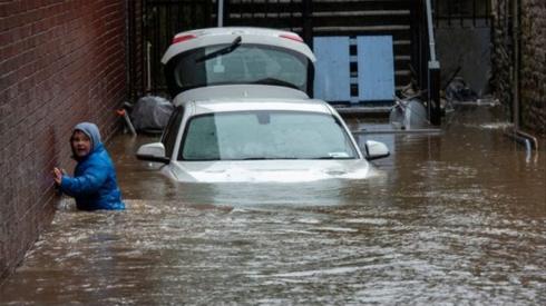 A boy wades towards a flooded alleyway in Pontypridd during Storm Dennis