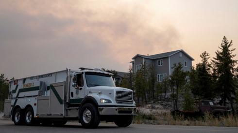 A Yellowknife Fire Department truck leaves a neighbourhood as smoke plumes near the city, after a state of emergency was declared, in Yellowknife, Northwest Territories, Canada on 15 August 2023