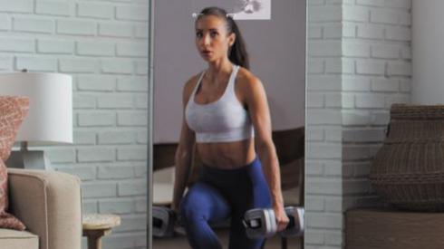 A woman's reflection in a smart fitness mirror