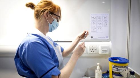 A nurse prepares a coronavirus vaccine
