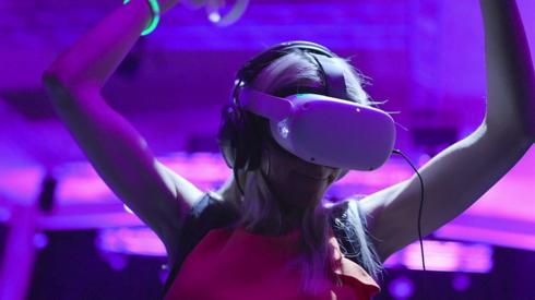 Click reporter Lara Lewington wears a VR headset. She has her arms in the air as she dances to music.