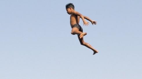 Children jump into the water of the Nile.