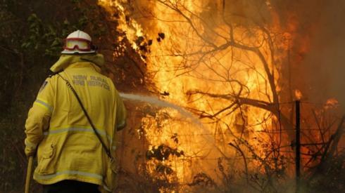 A firefighter works to contain a fire near Taree, New South Wales, Australia, 12 November 2019.