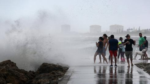 A wave crashes ashore as people enjoy the wind and waves kicked up by Tropical Storm Isaias as it passes through at Jetty Park on August 02, 2020 in Fort Pierce, Florida.