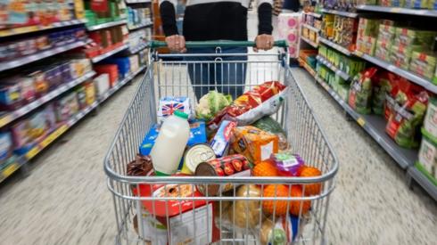 woman with a shopping trolley full of groceries in a supermarket