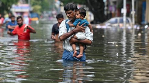 People walking through flood water in India