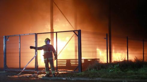 Firefighter in front of industrial estate blaze