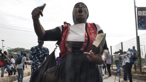 A female preacher holding Holy Bible eco slogans during civil demonstration at the Gani Fahweyinmi Park, Ojota district of Lagos, Nigeria, on 12 June 2021