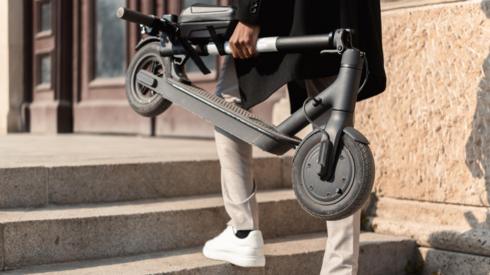 Man holding folded e-scooter