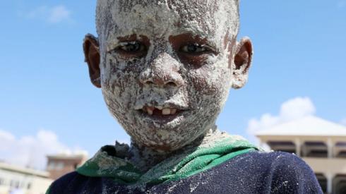 A Somali boy covers his face with sand at the Liido Beach during the last Friday ahead of the Muslim holy month of Ramadan, amid the coronavirus disease (COVID-19) pandemic in Mogadishu, Somalia April 9, 2021.