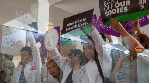 North Carolina physicians hold signs to protest as North Carolina Republican lawmakers hold a vote to uphold the 12-week abortion ban on 16 May 2023