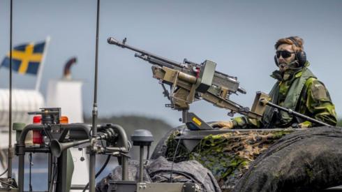 A Swedish soldier sits on a military boat with a machine gun during the Baltic Operations Nato military drills