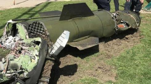 Two Ukrainian personnel looking at missile remains