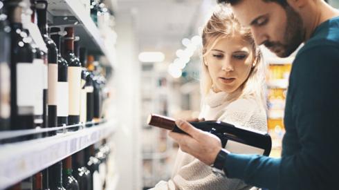 Couple buying wine in supermarket