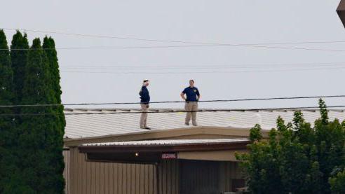 Investigators on the roof of the building where the attack was launched from