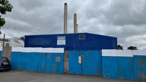 Blue building with blue boards in the foreground