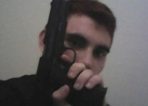 Nikolas Cruz, holding a gun in front of his face