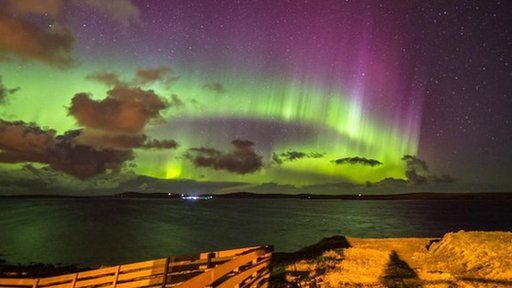 Green glow of the Northern Lights in the night sky