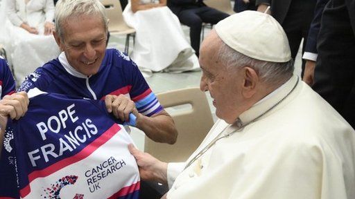 Andrew Gibson presents the Pope with a personalised cycling vest