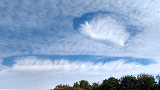 A two hole punch clouds, one more elongated than the other