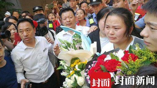 Kang Ying holding flowers, surrounded by her family