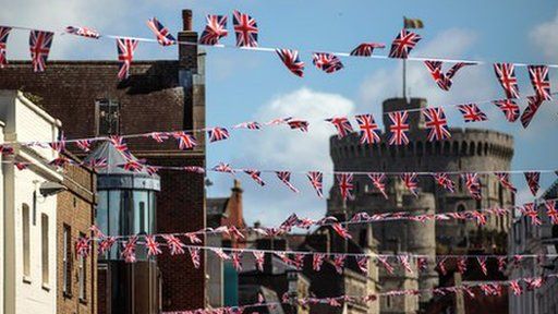 Bunting of the Union Jack hung on a street. Windsor Castle can be seen in the background