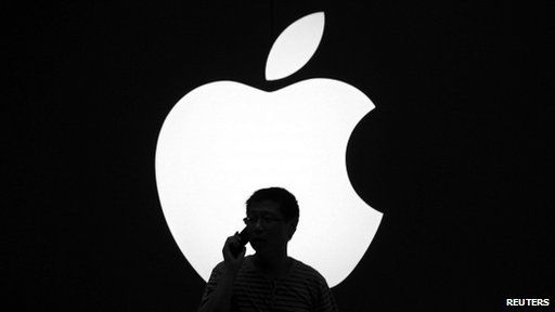 Man uses iPhone in front of Apple logo