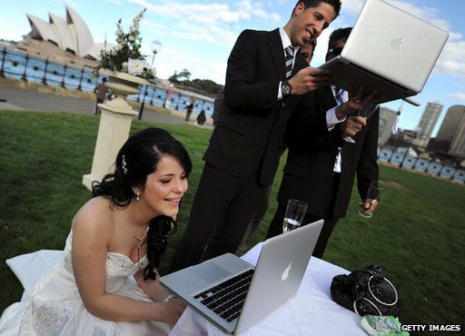 Bride and groom use laptops