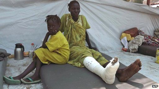 A girl sits next to a wounded relative after she received treatment at the Malakal Hospital in the Upper Nile State of South Sudan