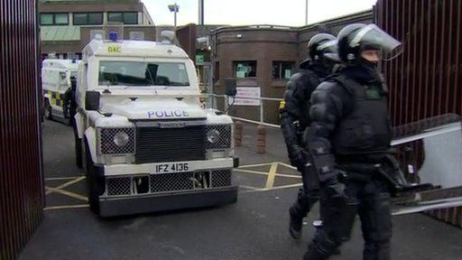 Police officers and vans emerging from Antrim PSNI base