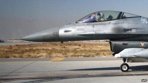 A pilot waves from the cockpit of a US F-16 fighter jet at Bagram air base, Afghanistan (2009)