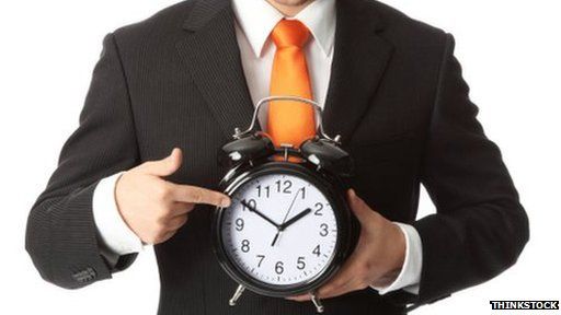 man holding a ticking clock
