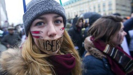 A woman wears tape across her mouth with the word "Liberte" (Freedom) written on it, during the unity march in Paris - 11 January 2015